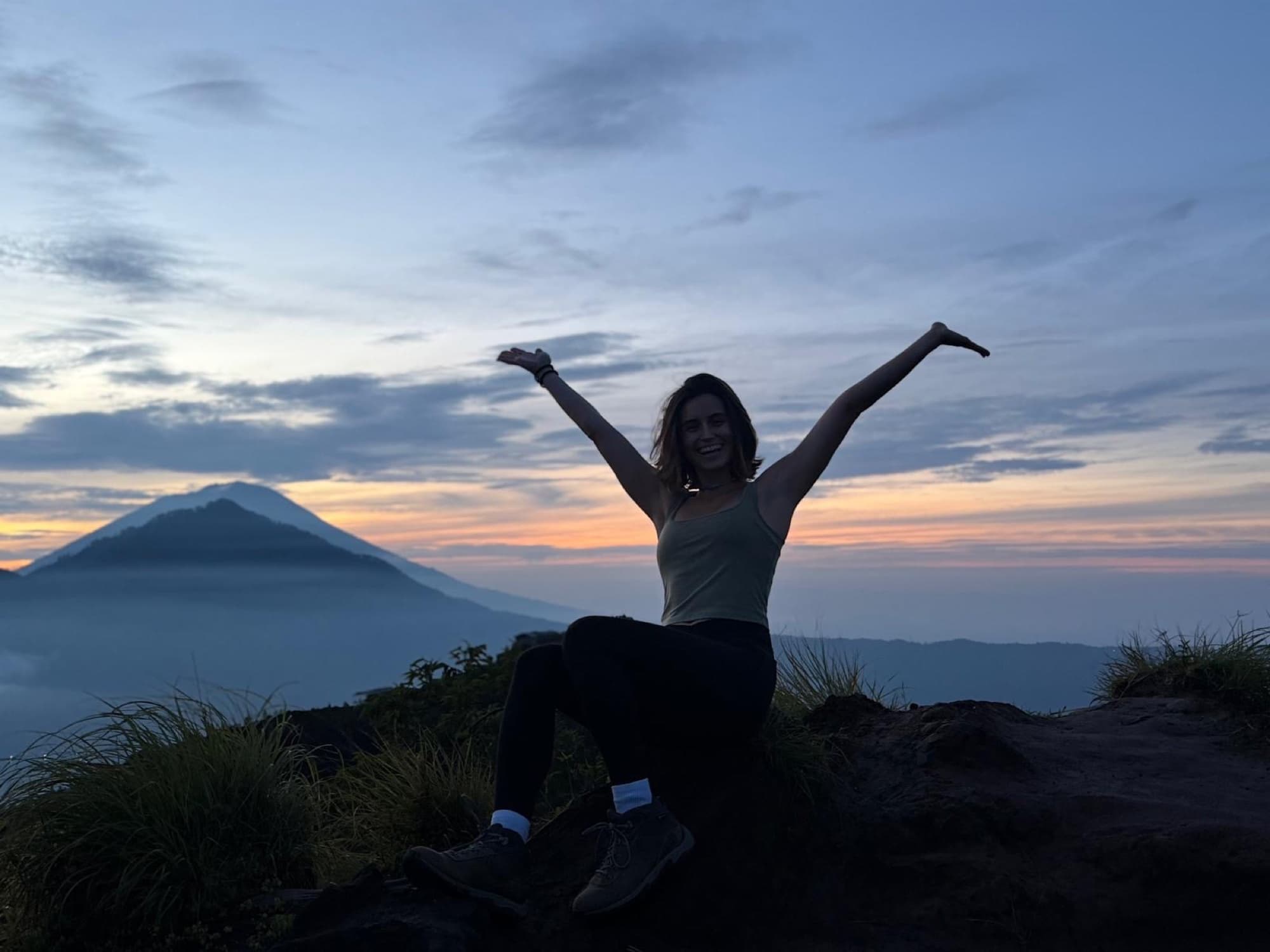 Rebecca in front of a volcano at sunrise during yoga teacher training in Bali